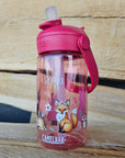 pinke camelbak flasche mit waldtiere und namen personalisiert in den händen eines Mädchens im wald