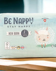 Vorderseite von hellgrüner, pastellfarbener Verpackung von Be Nappy Windeln für Neugeborene, Grösse Eins 2-5kg. Mit Schafmotiv und Gütesiegel auf Verpackung. Verpackung beinhaltet 27 Windeln.