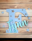 Stehende Namensdekoration aus blauem Acrylglas, mit Buchstaben und türkisem Namen personalisiert.