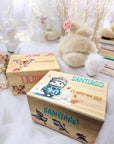 Designs von Erinnerungskisten mit Igel-in-Kleidung Motiv sowie personalisiert mit grünem und rosa Namen und Geburtsdaten im Kinderspielzimmer