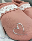 Nahaufnahme von rosa Lederfinken für Kinder mit beigem Oberleder, welches mit Boho-Regenbogen Motiv bestickt ist. Die Sohle ist aus grauem Leder und rutschfest.