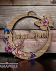 Rundes Namensschild von Mamawerk, aus Holz und mit Schmetterlingen und Blüten bedruckt.