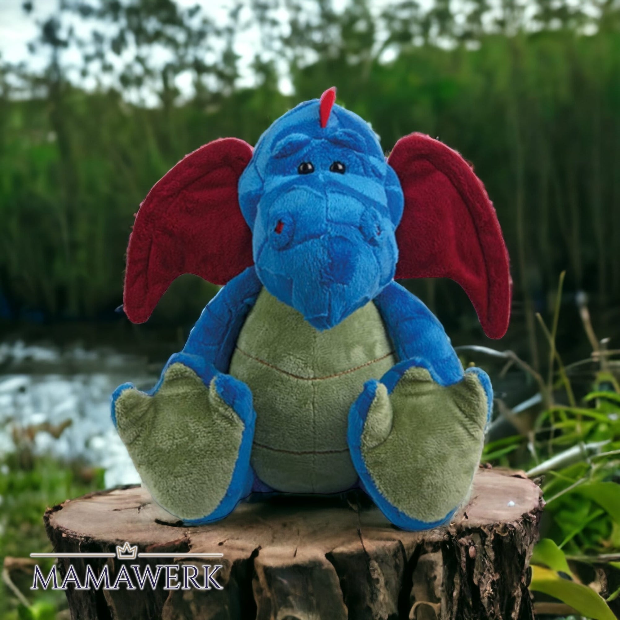 Kuscheltier Drachen Motiv, draussen auf Holz sitzend