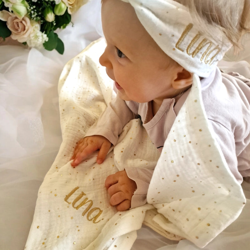 baby-mit-bandana-stirnband-weiss-bestickt-mit-namen-und-nuschi-bestickt-mit-namen-gold