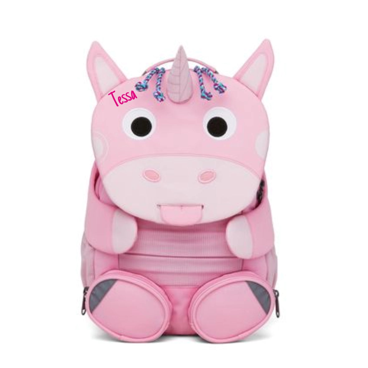 Rosa Kinderrucksack mit Einhorn als Klappe. Zunge rausgestreckt und ausziehbar. Personalisiert mit Namen auf Stirn. Zwei pinke Füsse dienen als Vordertaschen mit Reissverschluss.