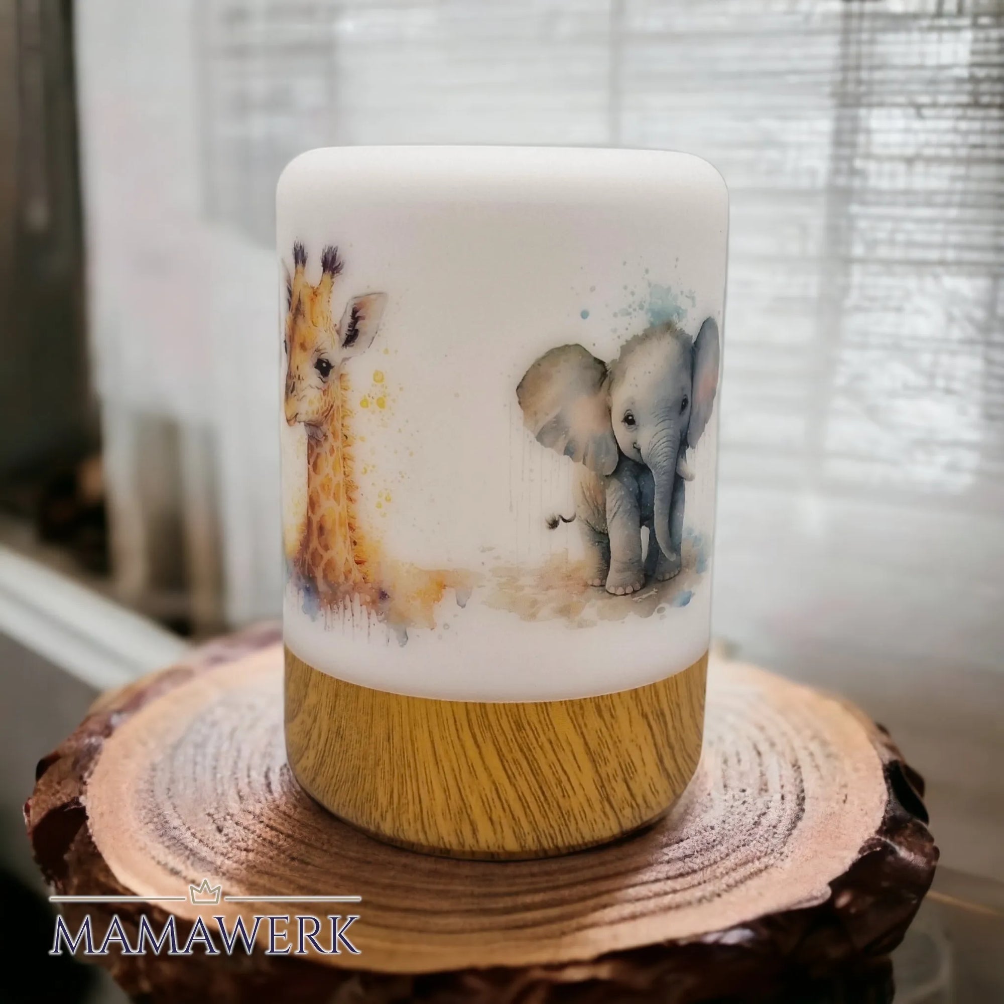 LED-Nachtlicht mit Holzsockel und Giraffen- und Elefant-Motiv, auf Holzrondelle stehend vor weissem Vorhang.