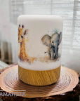 LED-Nachtlicht mit Holzsockel und Giraffen- und Elefant-Motiv, auf Holzrondelle stehend vor weissem Vorhang.