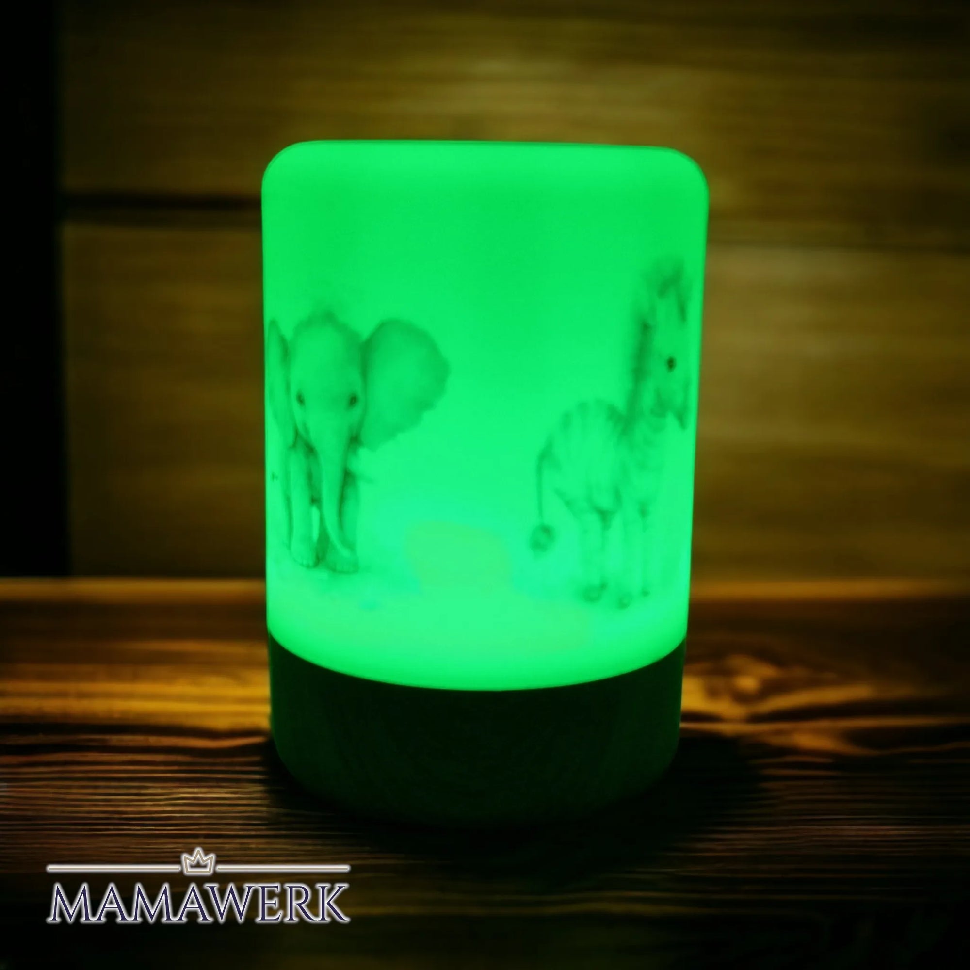 Grün erleuchtetes LED-Nachtlicht für Kinder mit Boho- Elefant und Zebra Motiv. Mit Holzsockel, auf Holztisch stehend.