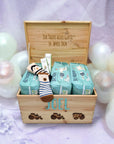 Ein Taufgeschenk für Jungen. Eine Baustellen Fahrzeug Erinnerungskiste, personalisiert mit Namen und einer persöönlichen WIdmung auf der Innenseite des Deckels. In der Kiste sind drei Packungen Windeln, Socken und Pflegecreme.
