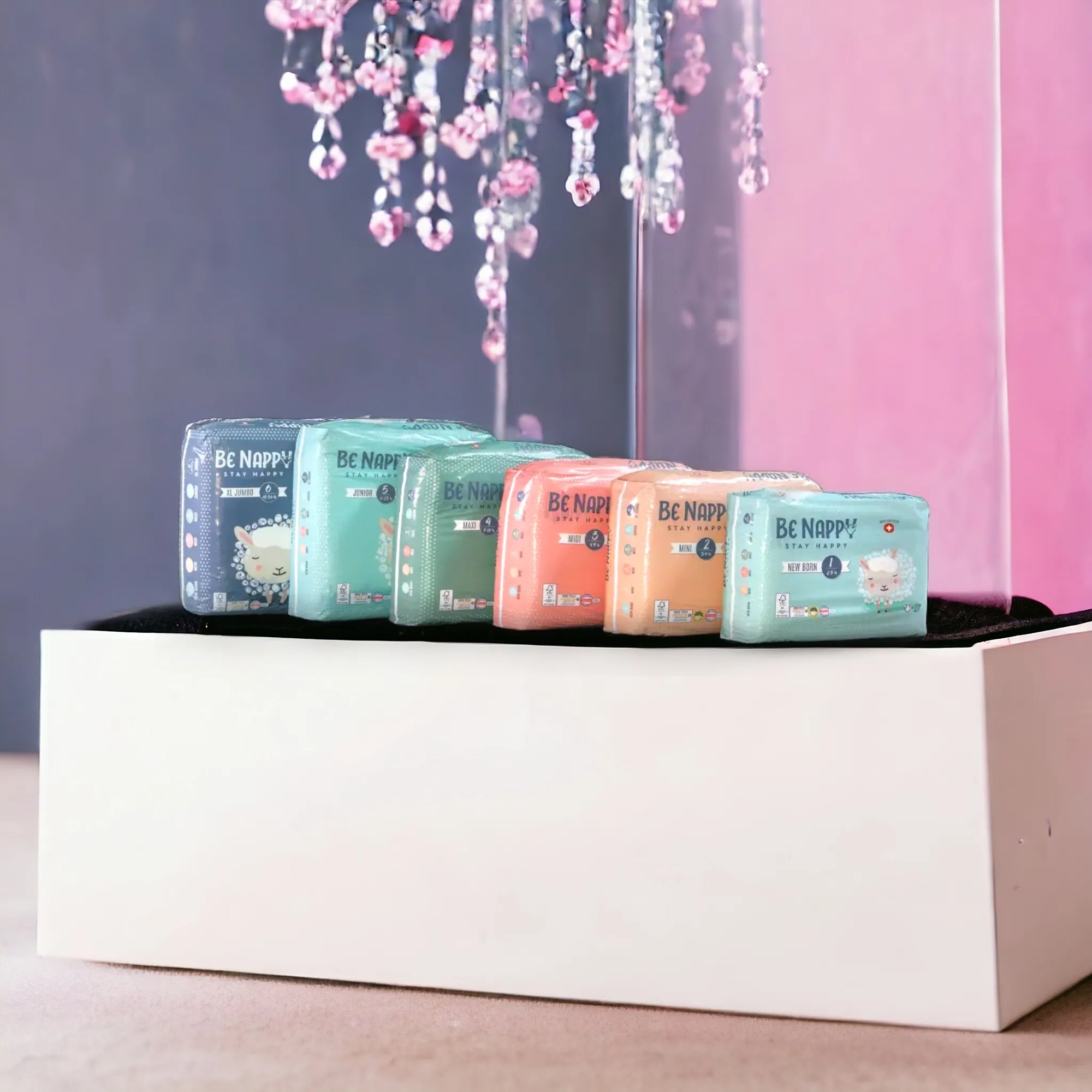 Windersortiment von Benappy WIndeln aufgereiht auf Garderobenbank. Alle unterschiedlichen Gössen haben eine andere Farbe der Verpackung
