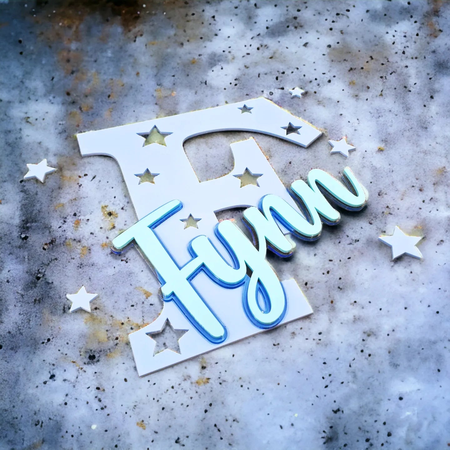 Stehende Namensdekoration aus blauem Acrylglas, mit Buchstaben und türkisem Namen personalisiert.