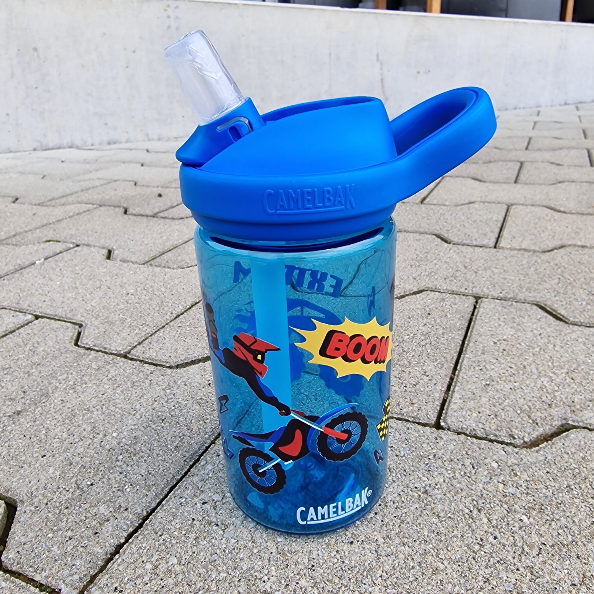 Camelbak Kinder Trinkflasche Motocross. Blauer eddy Camelbak Trinkflasche für Kinder, mit Motocross Monstertruck-Motiv und mit Namen personalisiert. Blauer Aufsatz mit Strohhalm.