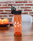 Auf einem Tisch steht eine Orange Camelbak Trinkflasche mit MOM (Mama) Schriftzug und den individuellen Kindernamen mit Herz darüber personalisiert. Schwarzer Verschlussgriff mit durchsichtigem Strohhalm
