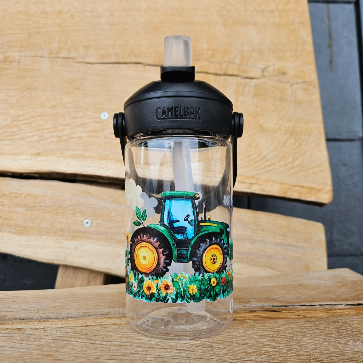 kleiner junge mit camelbak trinkfalsche und john deere motive und namen personalisiert auf einer wiese 