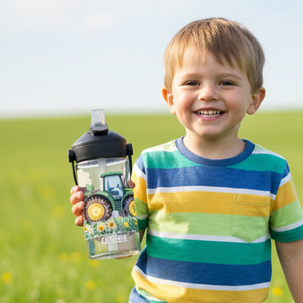 kleiner junge mit camelbak trinkfalsche und john deere motive und namen personalisiert auf einer wiese 