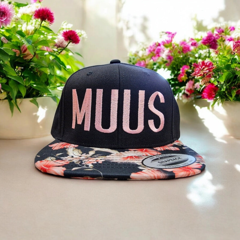 flexfit caps snapback und farbigem Schild mit muus motiv gestickt in rosa mit blumen im hintergrund