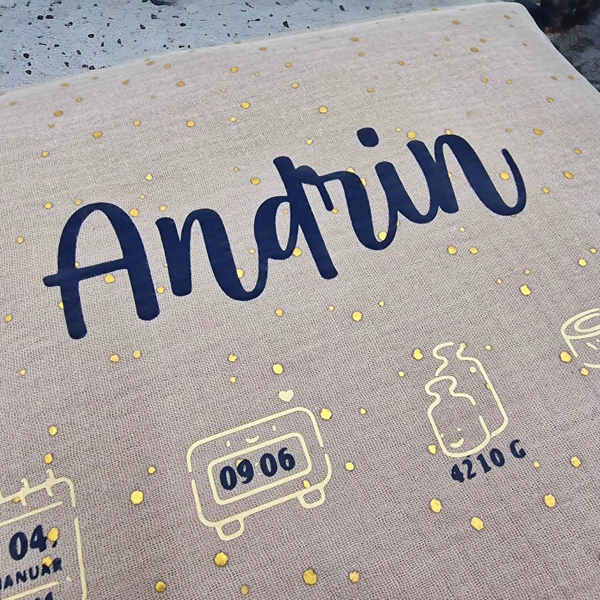 Kirschkernkissen als Wärmekissen, mit beigem Baumwollstoff und goldenen Tüpfchen, personalisiert mit schwarzem Namen und Geburtsdaten.