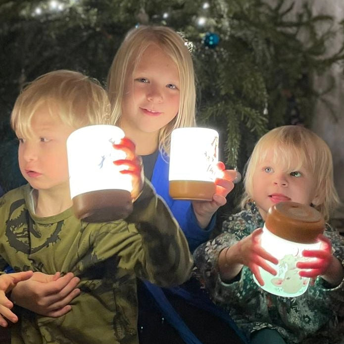 glückliche kinder unter weihnachtsbaum mit led touch nachtlichter