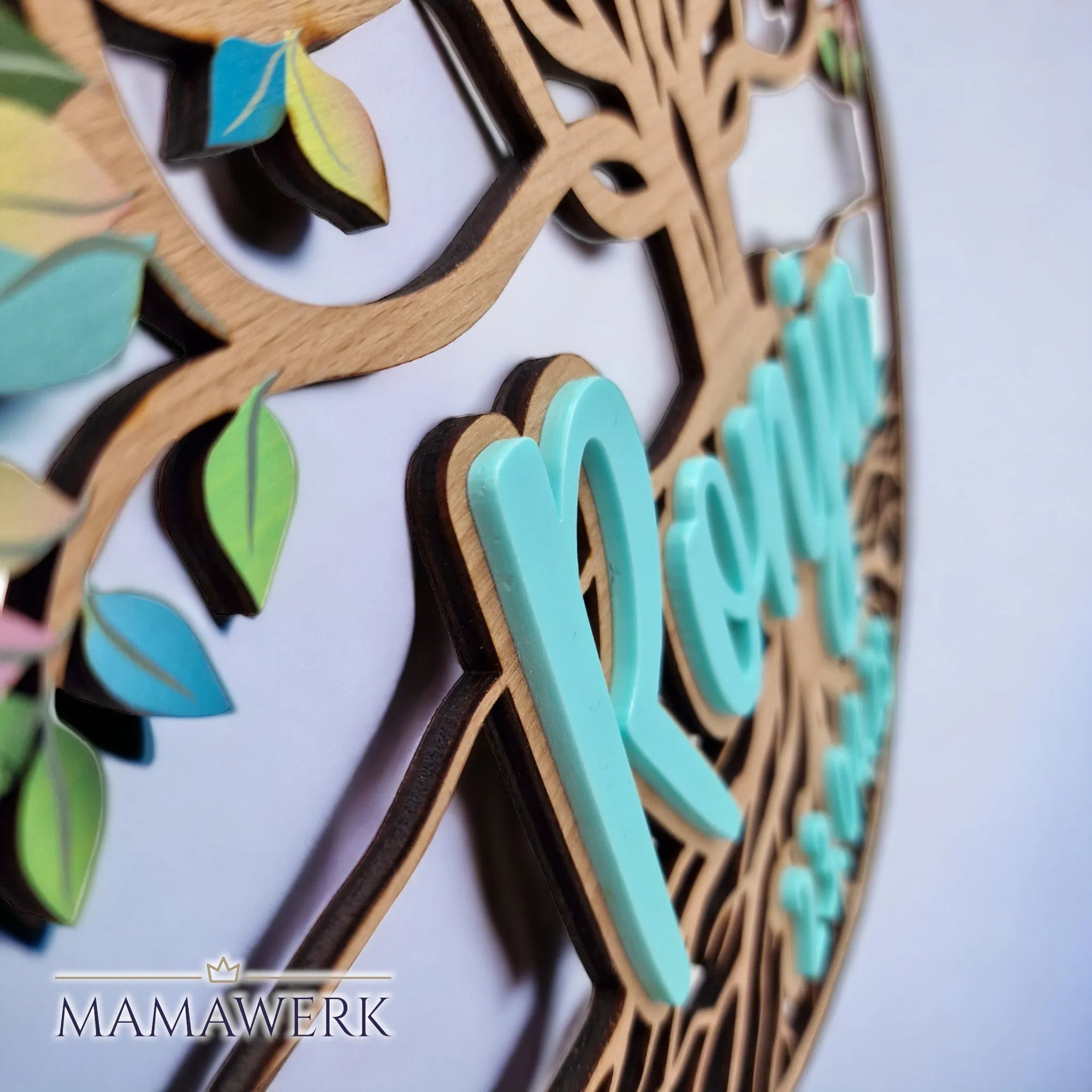 Rundes Namensschild von Mamawerk aus Holz, mit blauem Namen und Geburtsdatum aus Acrylglas sowie Lebensbaum mit farbigen Blättern bedruckt.