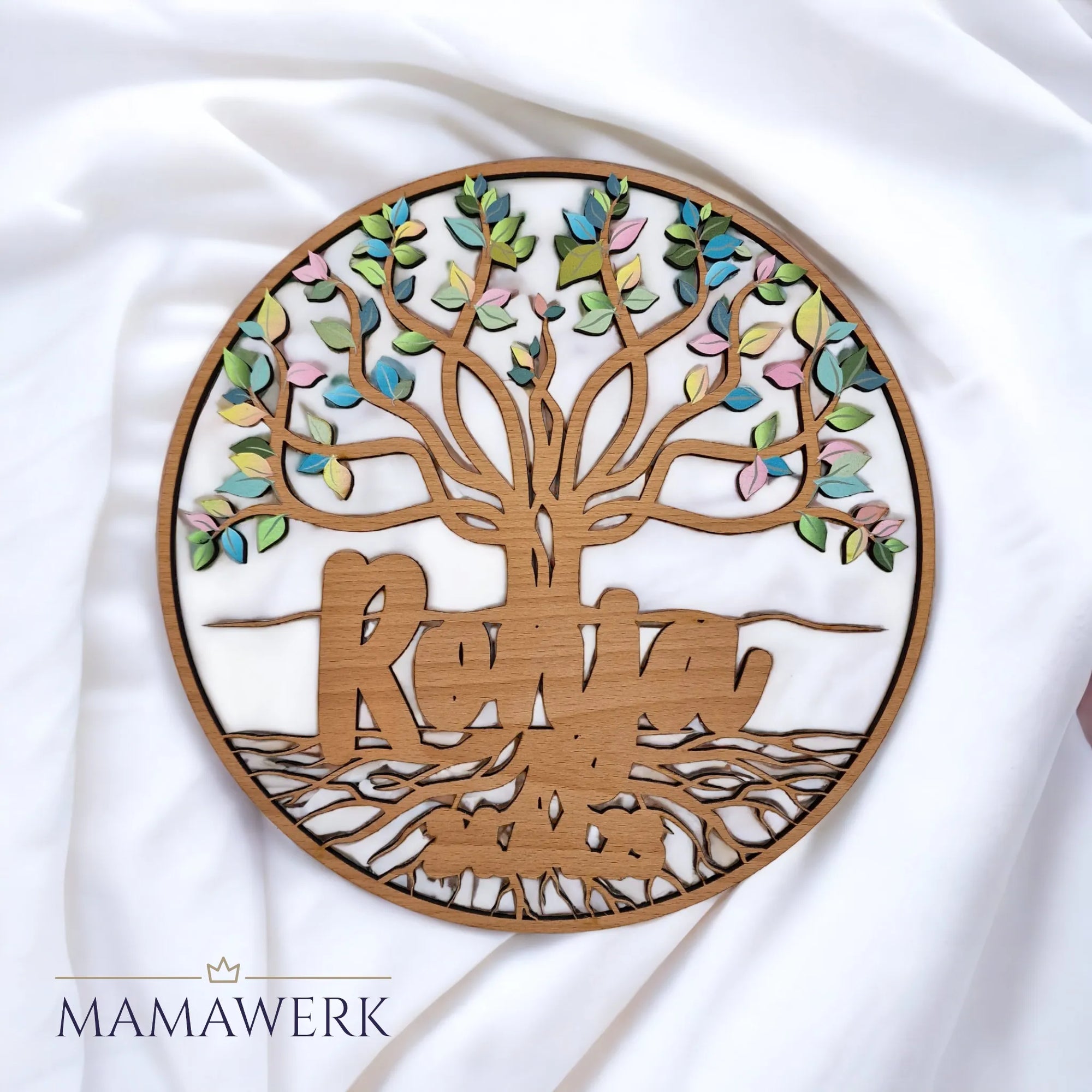 Rundes Namensschild von Mamawerk aus Holz, mit Namen und Geburtsdatum sowie Lebensbaum mit farbigen Blättern bedruckt.