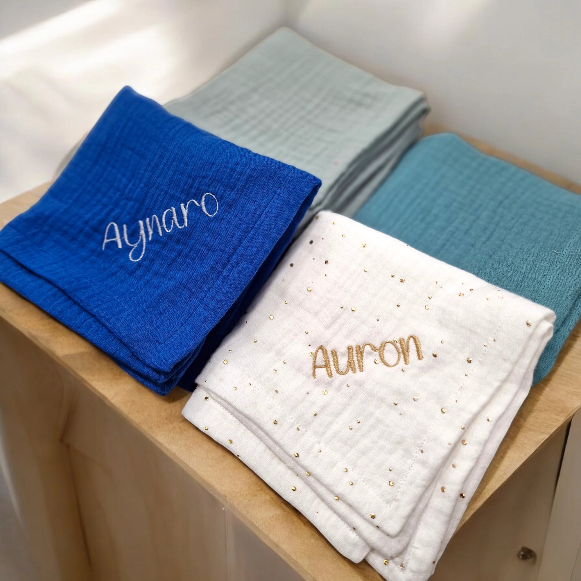 selbstgenähte nuschis aus musselin in der farbe blau, aqua, weiss und mint individuell bestickbar mit namen